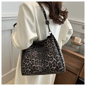 Detail of leopard print tote bag featuring a knotted shoulder strap and vintage metal ring