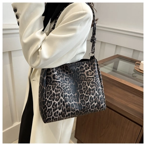 Detail view of large leopard print tote bag with metal ring and knotted shoulder strap