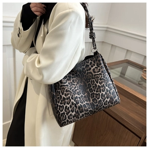Detail of leopard print tote bag with silver ring hardware and knot shoulder strap detail