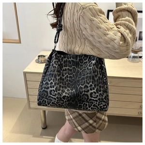 Leopard print tote bag detail with stylish knot strap design on model's shoulder