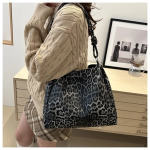 Detail view of leopard print tote bag with stylish knot strap on a model shoulder