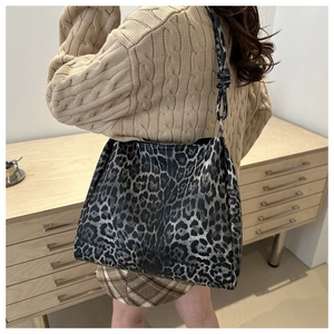 Detailed view of the knotted shoulder strap on a leopard print large tote bag