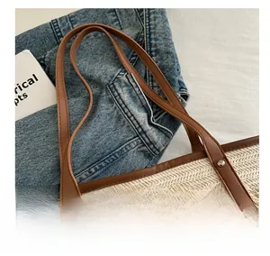 Détail du sac tissé beige avec poignées en cuir marron et rivets métalliques robustes
