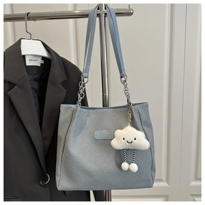 Light blue tote bag detail with twill texture and cute white cloud plush pendant charm