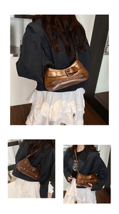 Detail of a brown Y2K vintage underarm bag with metal eyelets and decorative buckles