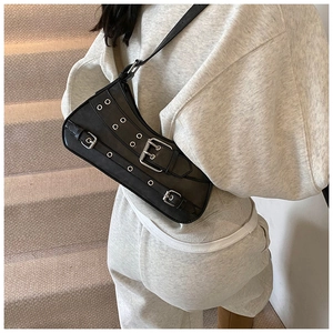Detail of black punk leather bag featuring silver metal buckles and eyelets textures