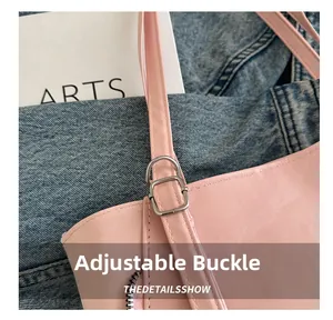 Detail of silver adjustable buckle and D-ring on pink leather tote bag strap