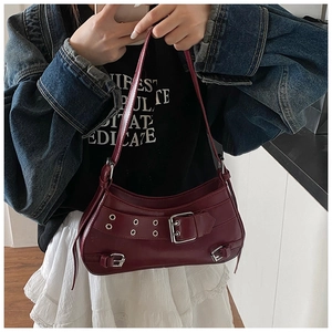 Close-up of wine red PU leather underarm bag featuring silver eyelets and buckle detail
