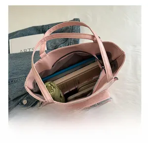 Pink tote bag interior showing large capacity with umbrella, books, and wallet