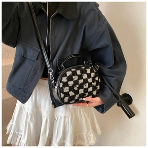 Details der Umhängetasche aus Tweed mit schwarz-weißem Karomuster am Model
