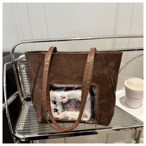 Detail of a vintage dark brown Ita bag with clear window and plush cat insert