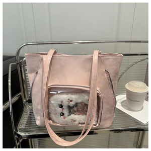 Detailed view of pink faux leather tote bag featuring a cute transparent cat pocket design