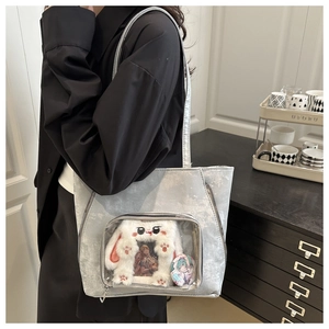 Détail du sac ita argenté montrant la fenêtre transparente avec badge anime et peluche lapin