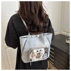 Silver metallic tote bag with clear PVC window featuring DIY plush toy and pins