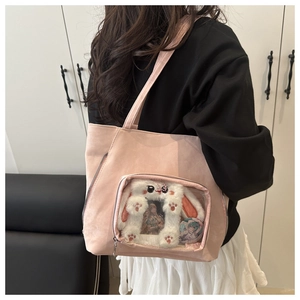 Detail of pink faux suede tote bag featuring a transparent window and plush bunny charm