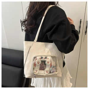 White canvas ita bag with transparent PVC window showing plush rabbit frame and anime badge