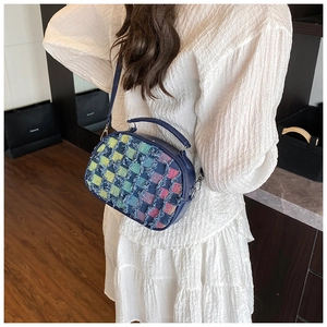 Detail of colorful patchwork shell bag with denim texture and metallic strap hooks