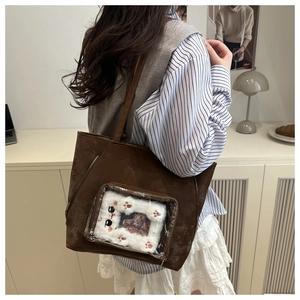 Detail of dark brown faux suede tote bag with transparent pocket and plush cat design