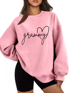 Close-up of pink crewneck sweatshirt featuring black grammy text and heart graphic detail