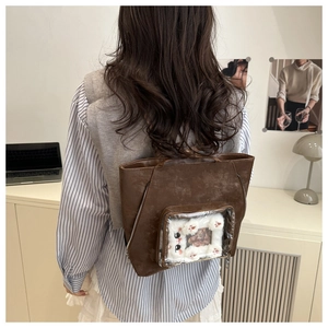 Détail d'un sac ita vintage marron avec fenêtre transparente et insert de chat en peluche