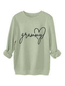 Close-up of light green sweatshirt fabric showing soft texture and grammy heart print