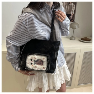 Close-up of black ita bag featuring a transparent window with cute plush cat card holder