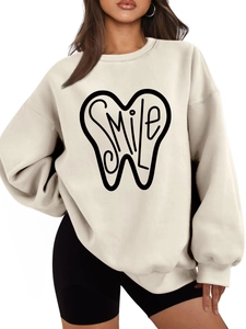 Detail of oversized beige sweatshirt showing Smile tooth print and drop shoulder design