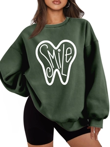 Detail of artistic SMILE tooth print on a thick dark green oversized crewneck sweatshirt
