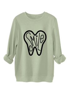 Close-up of ribbed cuffs and SMILE tooth print on thick sage green sweatshirt