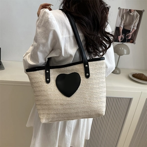 Sac fourre-tout en paille beige avec patch cœur noir et poignées en cuir chic