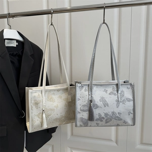 Chic butterfly pattern tote bags in cream and grey with decorative tassels and long straps
