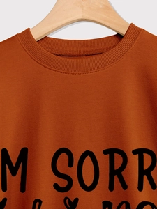 Detail of caramel crewneck sweatshirt featuring ribbed collar and I'M SORRY print