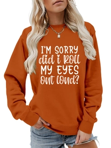 Detail of the orange crewneck sweatshirt featuring white bold slogan text and ribbed cuffs