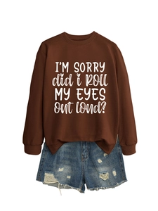 Detail of loose brown sweatshirt with white text and distressed denim shorts flat lay