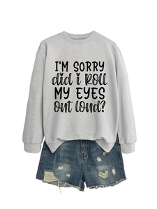 Detail of grey sweatshirt with 'I'M SORRY' slogan and distressed denim shorts ensemble