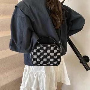 Chic black and white checkerboard shell bag with fringe texture and black leather straps
