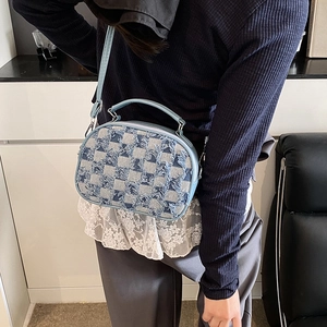 Blue denim shell bag featuring checkered fringe design with adjustable crossbody strap