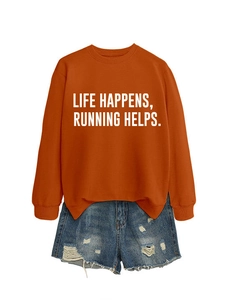 Flat lay of an orange sweatshirt with 'LIFE HAPPENS, RUNNING HELPS' text and denim shorts