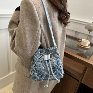 Blue denim quilted bucket bag with frayed diamond pattern and drawstring closure