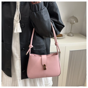 Detail of pink PU leather underarm bag with knot strap and vintage metal lock closure