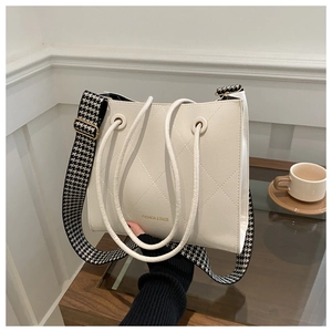 Dettaglio della borsa tote trapuntata crema con scritta fashion e tracolla pied-de-poule