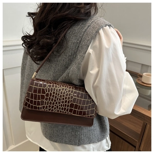 Detail showing deep brown faux crocodile texture and smooth leather on shoulder bag