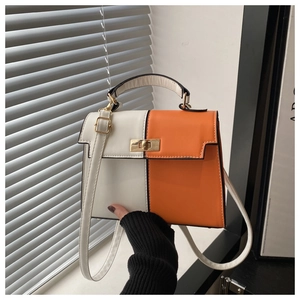 Détails du sac à main bicolore blanc et orange avec boucle rotative en métal doré