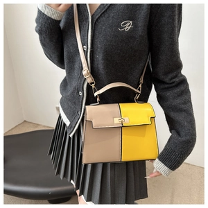 Detail of color-block handbag in khaki and yellow with golden square twist lock