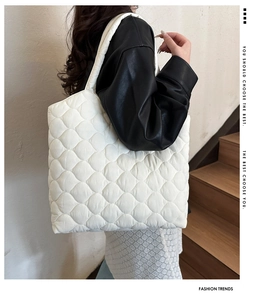 Detailed view of the white quilted tote bag with diamond pattern and soft shoulder strap