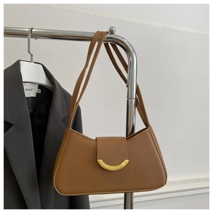 Detailed view of brown leather shoulder bag with elegant golden half-moon metal buckle