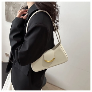 Close-up of cream white underarm bag with iconic golden crescent metal buckle detail