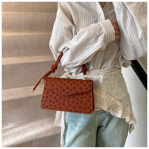Borsa a tracolla vintage marrone con stampa a quadrifoglio indossata da modella