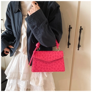 Detail der rosapink geprägten Handtasche mit Kleestruktur und geknotetem Seilgriff