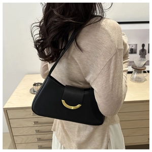Detail of minimalist black PU leather shoulder bag with gold crescent buckle on model